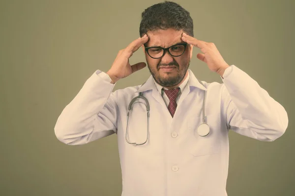 Homem barbudo persa médico contra fundo colorido — Fotografia de Stock