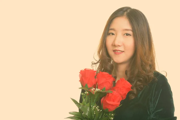 Młody szczęśliwy Azji kobieta gospodarstwa czerwone róże gotowy dla Walentynki — Zdjęcie stockowe