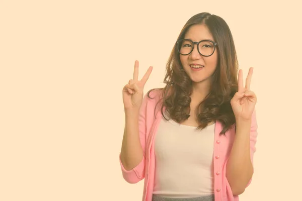 Giovane donna asiatica felice dando segno di pace — Foto Stock