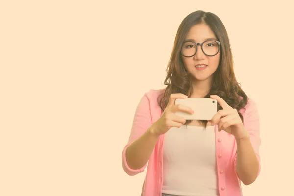 Joven mujer asiática feliz tomando fotos con teléfono móvil —  Fotos de Stock