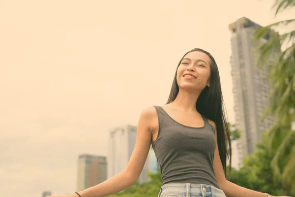 Ung vacker asiatisk kvinna avkopplande i parken — Stockfoto