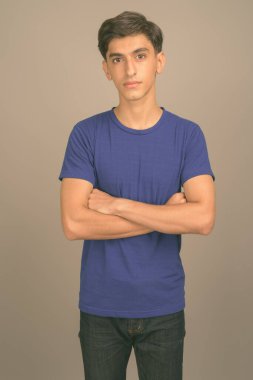 Gri arka planda genç yakışıklı İranlı genç çocuk