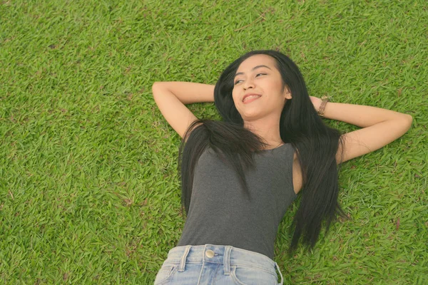 Jeune belle femme asiatique relaxant au parc — Photo