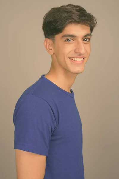 Gri arka planda genç yakışıklı İranlı genç çocuk — Stok fotoğraf