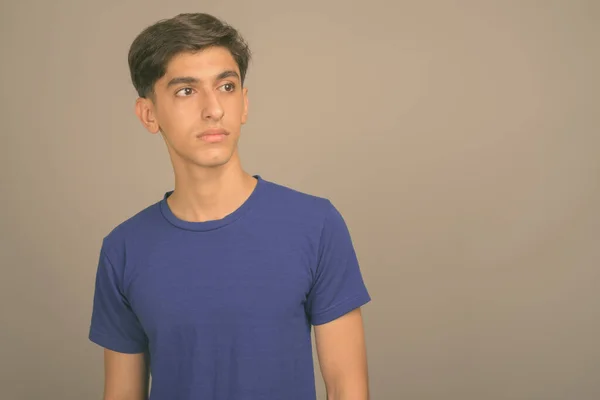 Giovane bel ragazzo adolescente persiano contro sfondo grigio — Foto Stock