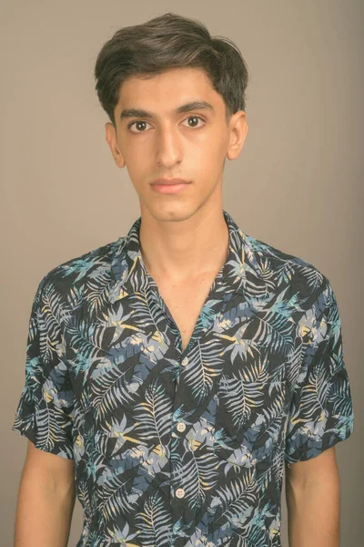 Ung stilig persisk tonåring pojke bär Hawaiian skjorta mot grå bakgrund — Stockfoto