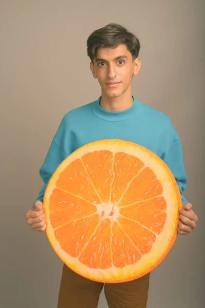 Joven guapo adolescente persa contra fondo gris —  Fotos de Stock