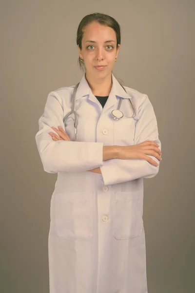 Young beautiful woman doctor against gray background — Stock Photo, Image
