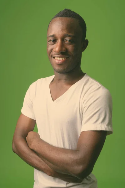 Genç Afrikalı adamın yeşil arka planda çekilmiş bir fotoğrafı. — Stok fotoğraf