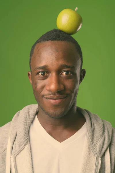 スタジオショットの若いアフリカ人男性のカジュアル服を着て緑の背景 — ストック写真