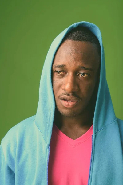 Studio Shot Młodego Afrykanina Niebieskiej Kurtce Różową Koszulą Zielonym Tle — Zdjęcie stockowe