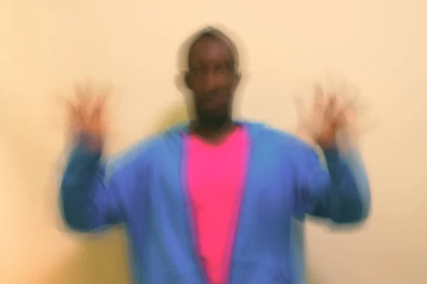 スタジオショットの若いですアフリカ人男性身に着けていますブルージャケットピンクのシャツと白の背景 — ストック写真