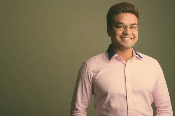 Indický podnikatel nosí růžovou košili na barevném pozadí — Stock fotografie