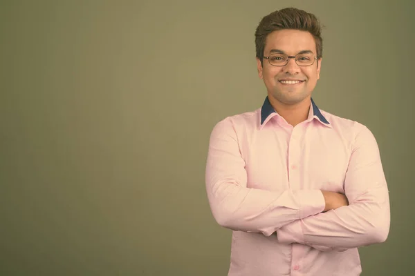 Indiska affärsman bär rosa skjorta mot färgad bakgrund — Stockfoto