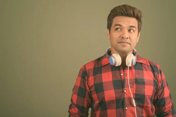색색 배경에 헤드폰을 쓰고 있는 인도 남자 — 스톡 사진