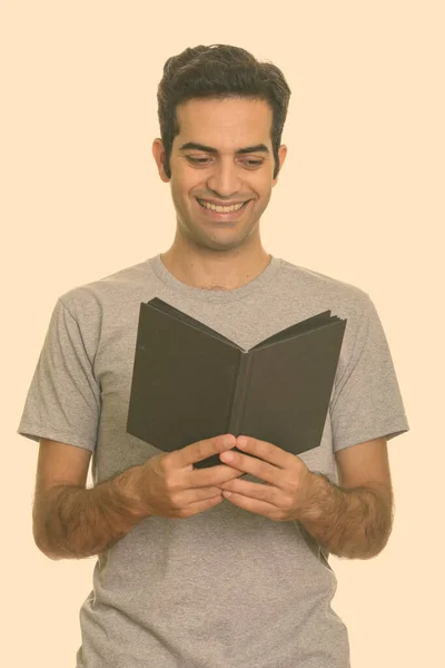 Portret van gelukkige jonge Perzische man lezen boek — Stockfoto
