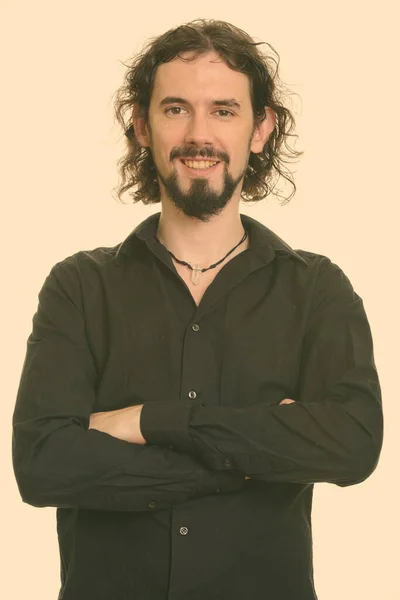 Retrato de feliz hombre de negocios barbudo guapo sonriendo con los brazos cruzados —  Fotos de Stock