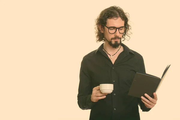 Bell'uomo caucasico che legge libro mentre tiene la tazza di caffè — Foto Stock