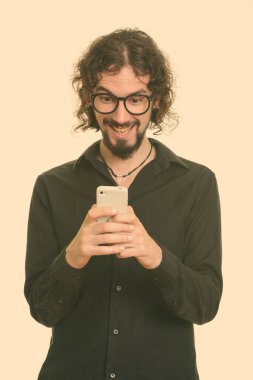 Mutlu yakışıklı beyaz adam cep telefonu kullanırken gülüyor.