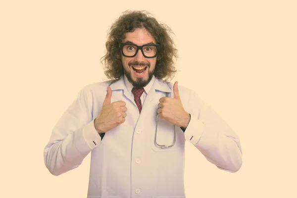 Студийный снимок счастливого человека доктор улыбается и дает большие пальцы вверх — стоковое фото