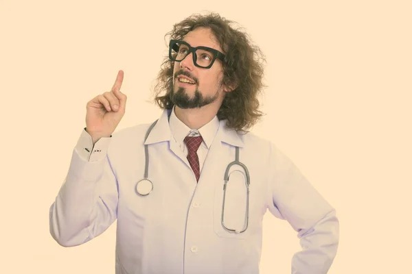 Studio colpo di felice uomo medico sorridente mentre pensa e punta il dito verso l'alto — Foto Stock