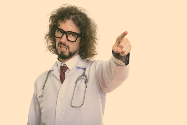Студійний знімок сердитого лікаря, який вказує пальцем на відстань — стокове фото