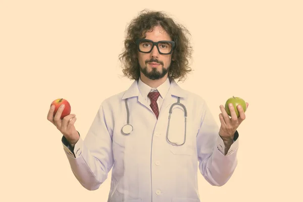 Studio strzał przystojny mężczyzna lekarz gospodarstwa czerwone jabłko i zielone jabłko — Zdjęcie stockowe