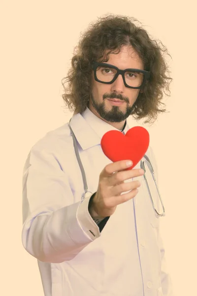 Студийный снимок красивого врача с красным сердцем — стоковое фото