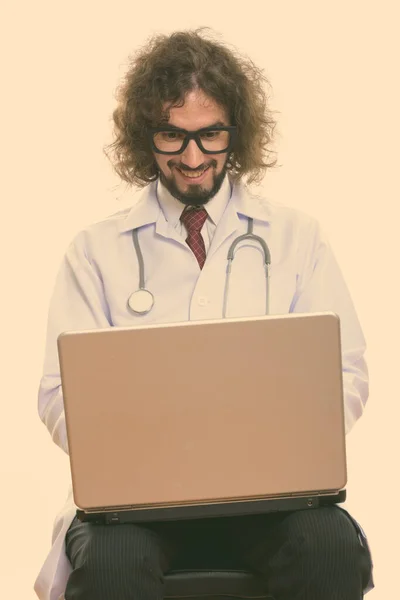 Студийный снимок счастливого врача, улыбающегося при помощи ноутбука — стоковое фото