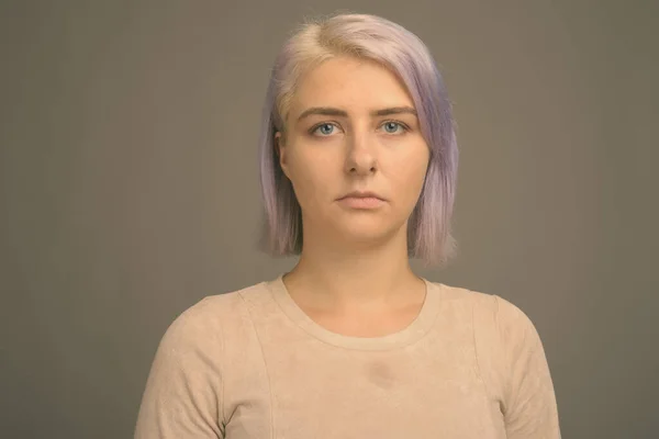 Junge schöne Rebellin mit bunten Haaren vor grauem Hintergrund — Stockfoto