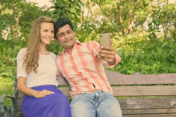 Feliz pareja multi étnica tomando selfie juntos y en el amor en el tranquilo parque verde — Foto de Stock