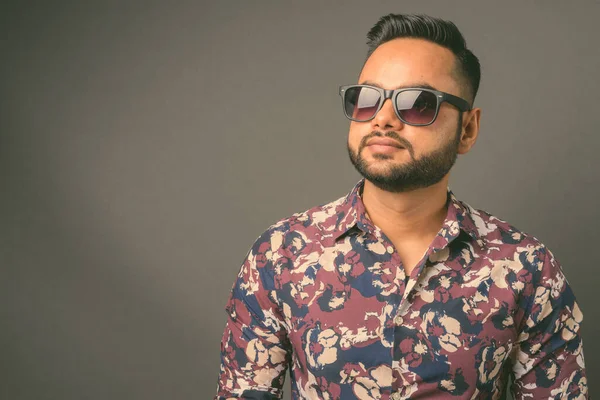 Joven barbudo hombre indio contra fondo gris — Foto de Stock