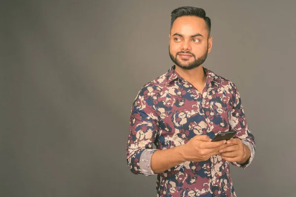 Young bearded Indian man against gray background — Stock Photo, Image