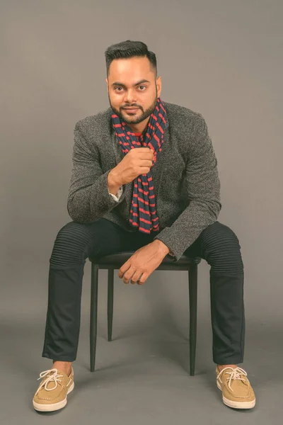 Junger bärtiger indischer Geschäftsmann mit grauem Hintergrund — Stockfoto