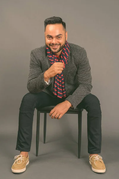 Junger bärtiger indischer Geschäftsmann mit grauem Hintergrund — Stockfoto