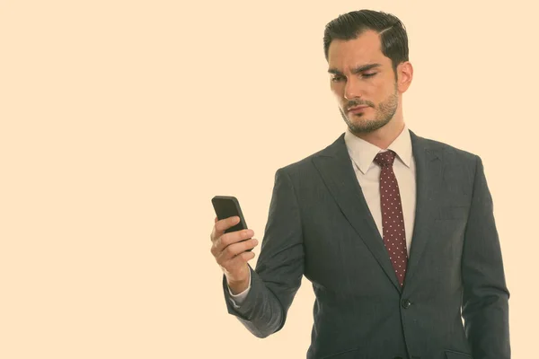 Студийный снимок молодого привлекательного бизнесмена с помощью мобильного телефона — стоковое фото