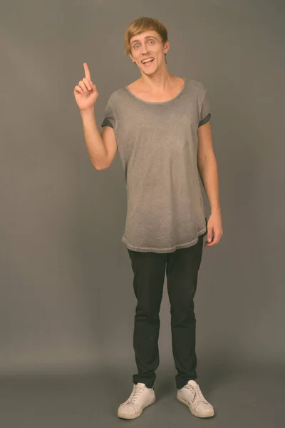 Joven hombre guapo con el pelo rubio sobre fondo gris —  Fotos de Stock