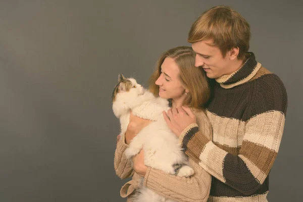 Studio shot van jong stel samen tegen grijze achtergrond — Stockfoto