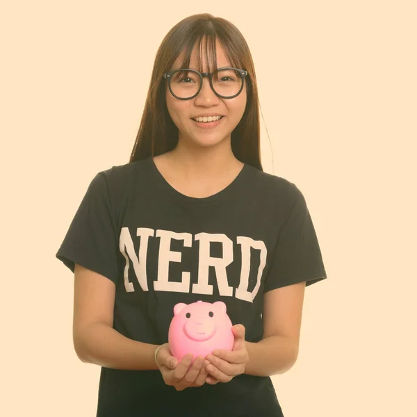 Giovane felice asiatico nerd adolescente ragazza sorridente e tenendo salvadanaio — Foto Stock