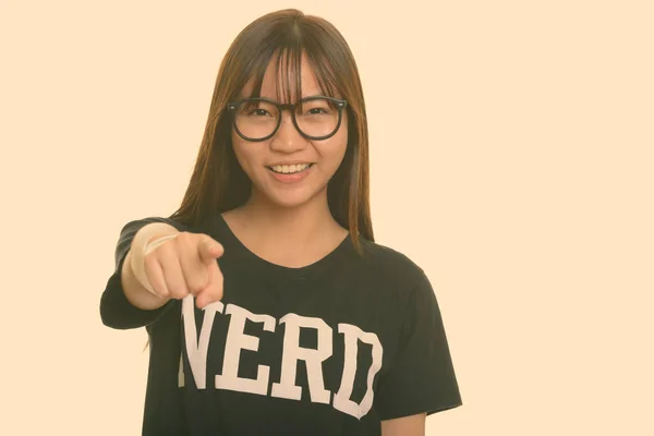 젊고 행복 한 아시아 괴짜 십 대 소녀가 웃으며 카메라를 향해 손가락 질하는 모습 — 스톡 사진