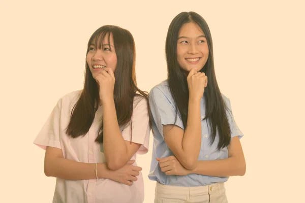 Δύο νεαρές ευτυχισμένες Ασιάτισσες κοπέλες χαμογελούν και σκέφτονται μαζί. — Φωτογραφία Αρχείου