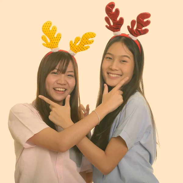 행복 한 젊은 아시아 십 대 소녀 두 명 이웃으며 크리스마스를 위해 함께 포즈를 취한다 — 스톡 사진