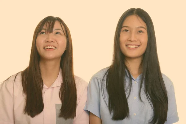 Zwei junge glückliche asiatische Teenager-Mädchen lächeln und denken — Stockfoto