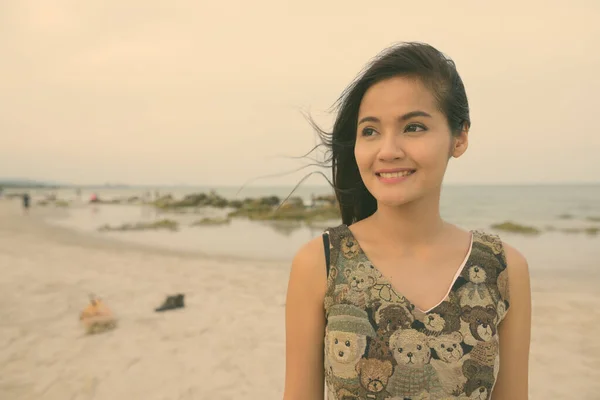 Nahaufnahme einer jungen glücklichen schönen Asiatin, die am öffentlichen Strand von Hua Hin in Thailand lächelt — Stockfoto