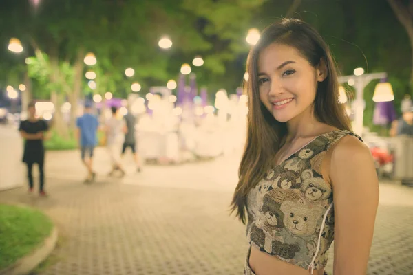 Joven mujer asiática feliz sonriendo contra la vista panorámica del mercado nocturno en Hua Hin Tailandia —  Fotos de Stock