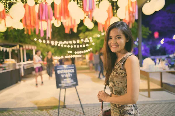 Jeune heureuse belle femme asiatique souriant à l'entrée du groupe ouvert dans le marché de nuit de Hua Hin Thaïlande — Photo