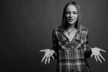 Studio shot of young beautiful rebellious woman with dyed hair against gray background in black and white