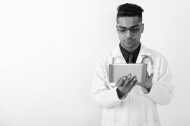 Siyah beyaz arka planda genç Hintli doktorun atölye fotoğrafı.