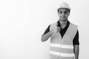 Siyah beyaz arka planda çalışan Hintli genç bir inşaat işçisinin stüdyo çekimi.