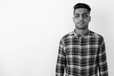 Siyah beyaz arka planda genç Hintli hippinin atölye çekimi.